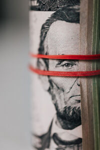Money roll with abe lincoln peering through the rubber band